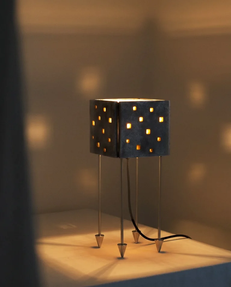Luminária de Mesa Prisma acesa em ambiente interno da Coleção Massiva da DONÓ Design.